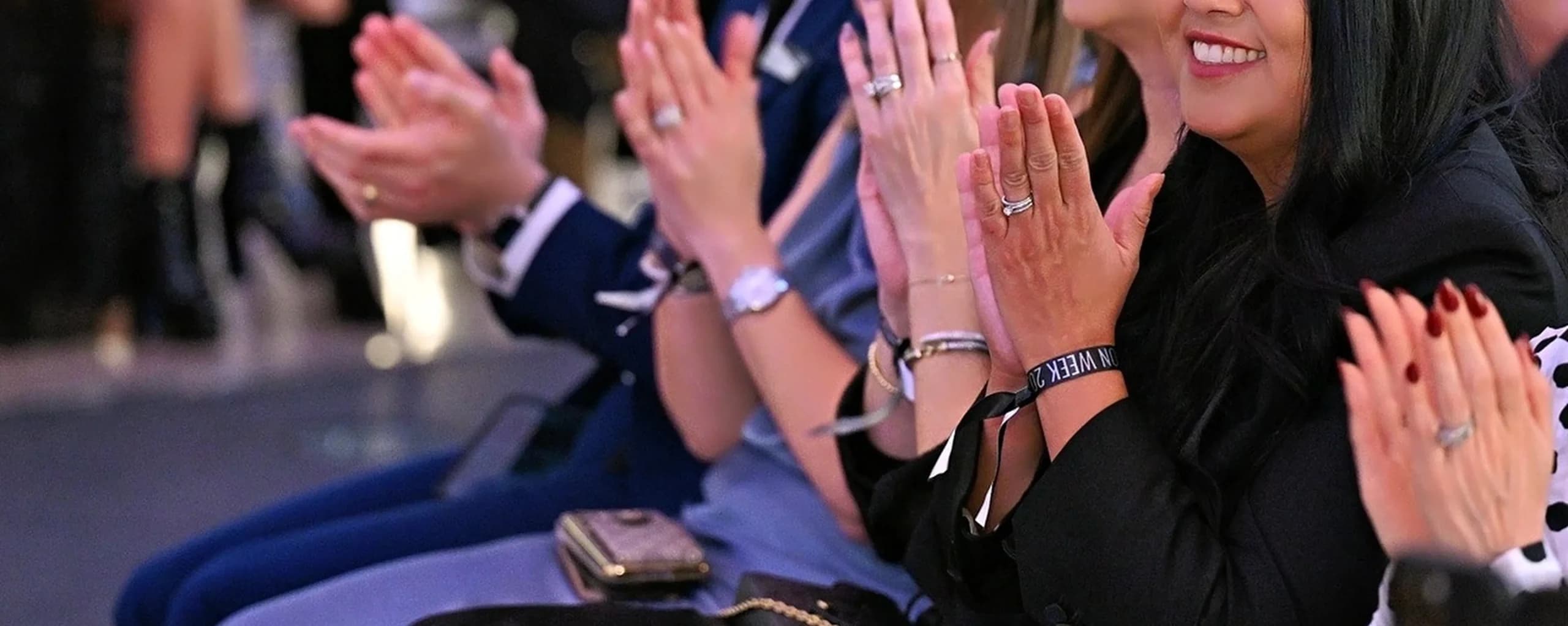Attendees applauding, one wearing a Vegas Fashion Week® event wristband