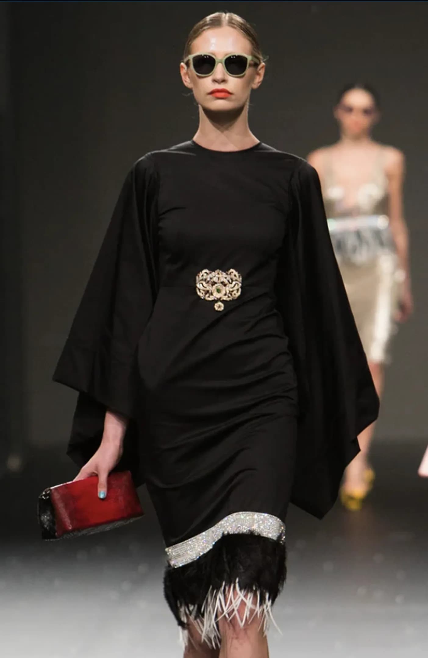 A model walking a Vegas Fashion Week runway in an embellished evening gown